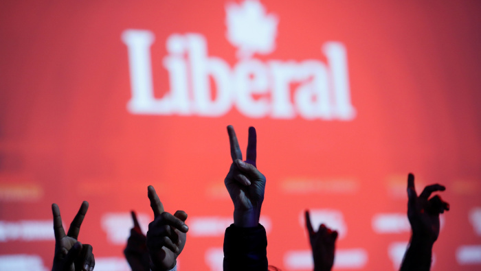 Militantes del Partido Liberal de Canadá hacen la señal de la victoria mientras miran los resultados de los comicios.