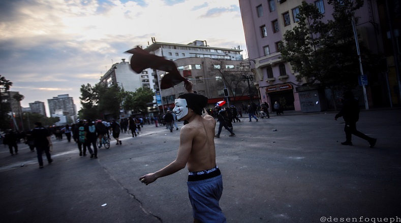 Fotografía tomada en la Avenida. Manifestante con máscara de anonymus (Santiago de Chile, 21 de octubre de 2019).