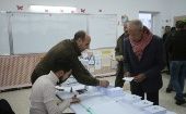 Un votante recibe una boleta en un colegio electoral durante las elecciones presidenciales en Argel, Argelia.
