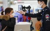 Personal de seguridad del Aeropuerto Jiangbei de Chongqing en China verifica la temperatura corporal de los usuarios.