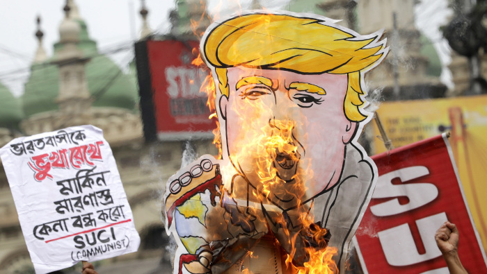 Activistas del Centro de Unidad Socialista de India (SUCI) queman un dibujo de Trump durante una protesta contra la visita del presidente de EE.UU.