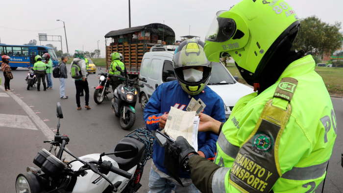 Policías colombianos verifican documentos y permisos a los ciudadanos que transitan las calles de Bogotá.