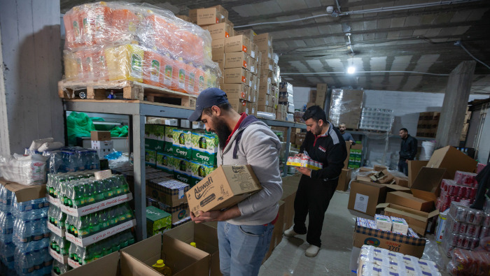 Voluntarios palestinos llenan cajas con suministros de comida donados a familias cristianas, en un almacén en la ciudad cisjordana de Belén.