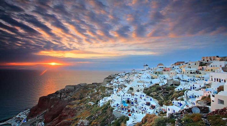 Oia es una localidad costera de Santorini, isla griega en el mar Egeo. Sus casitas parecen aferrarse a los acantilados de origen volcánico, desde donde puede verse el mar, las islas vecinas y unos atardeceres inigualables.