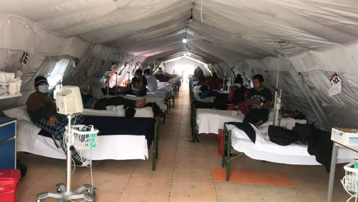Pacientes esperan atención médica acostados en colchonetas militares a las afueras del hospital IESS Quito Sur.