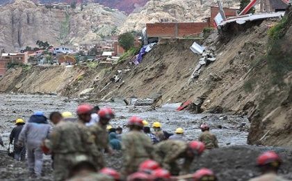 Militares bolivianos trabajan con maquinaria cerca de casas colapsadas por la crecida de ríos en la zona Callapa, en La Paz.
