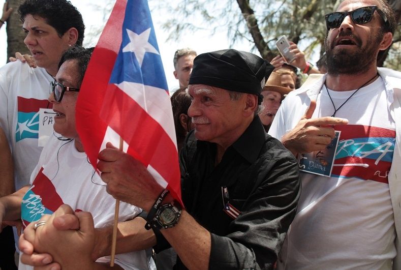 Puerto Rican Oscar Lopez Rivera (C) carries a national flag as he meets with supporters after being released from house arrest in San Juan, Puerto Rico May 17, 2017.