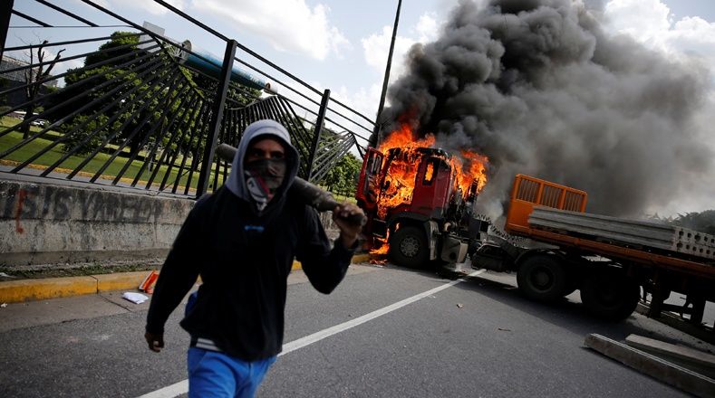 Fuerzas de choque vinculadas a la oposición venezolana arremetieron contra la base aérea militar de La Carlota en Caracas, Venezuela, quemaron tres camiones que utilizaron como obstáculos y usaron uno de los vehículos para estrellarlo contra la valla de la base.